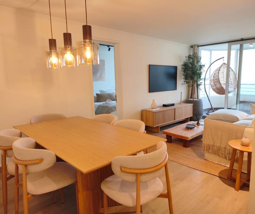 Comedor-living cálido con terraza y vista al mar de un departamento administrado por APTO